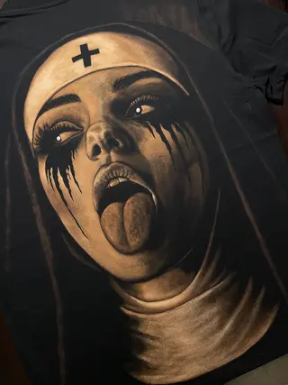 Nahaufnahme einer rebellischen Nonnenillustration in Bleach-Art-Technik mit ausdrucksstarken Details auf schwarzem T-Shirt