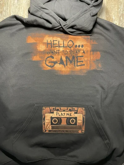 Closer view of the cassette and horror quote bleach design on the front of a black XL hoodie