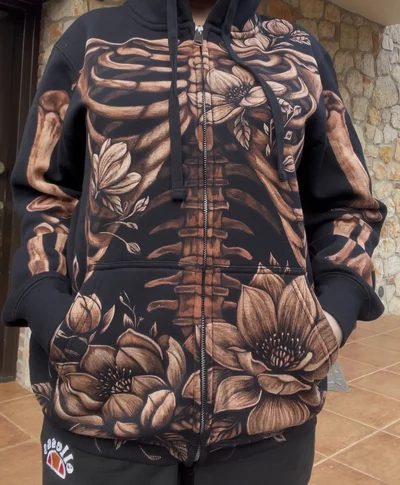 Close-up of skeleton and magnolia bleach art hoodie on model in natural light