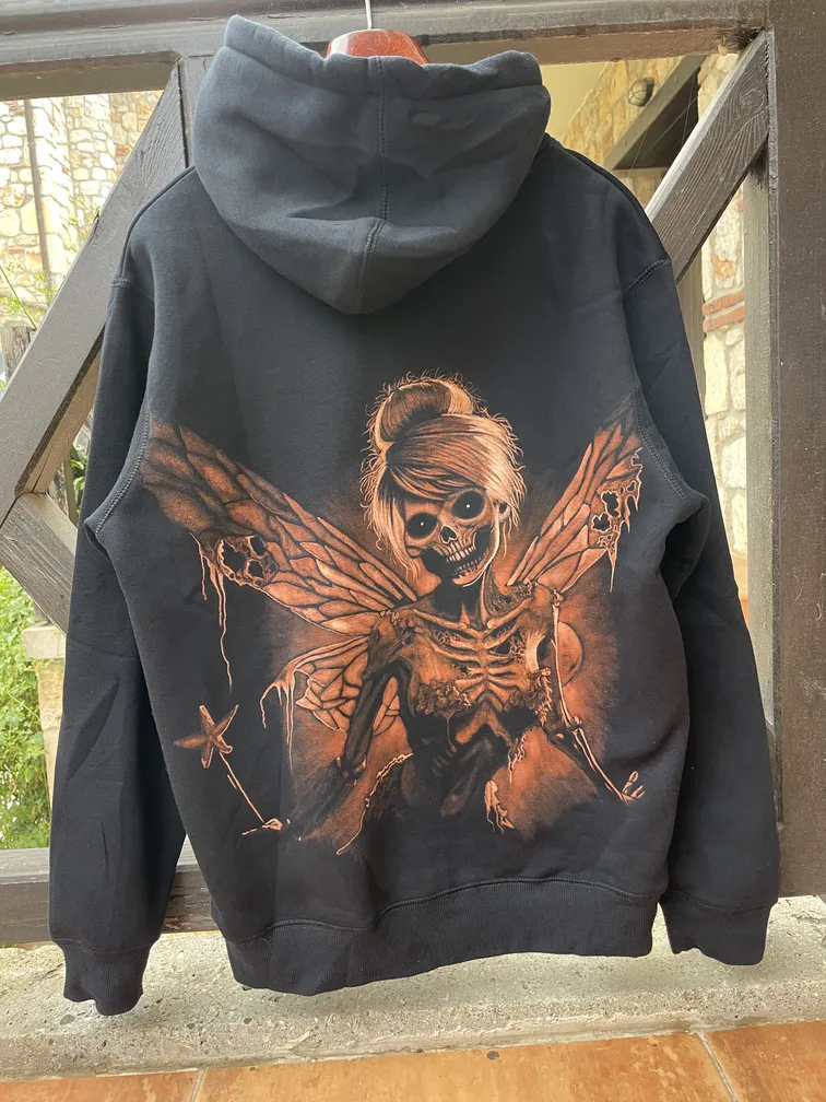 Skeleton fairy bleach art illustration covering the back of a black fleece hoodie
