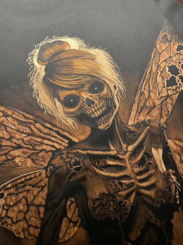 Close-up of a skeleton fairy bleach art illustration on the back of a t-shirt