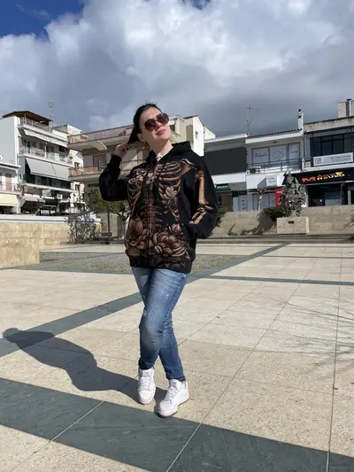 Full body view of skeleton and magnolia hand painted hoodie on model in natural light