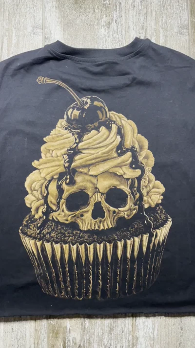 Video mit der vollständigen Rückansicht eines schwarzen Cropped-T-Shirts mit handgestaltetem Totenkopf-Cupcake in Bleach Art