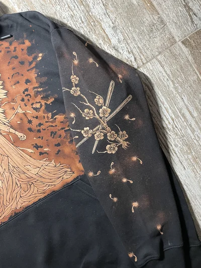 Linker Ärmel eines Sleep Token Bleach Art Hoodies mit Kirschblüten und Nadeln als Anspielung auf Thread the Needle