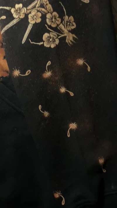Video des linken Ärmels mit Kirschblüten und langen Nadeln als Anspielung auf den Sleep Token Song Thread the Needle
