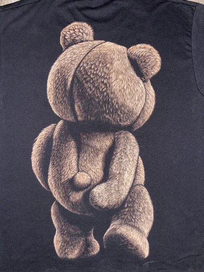 Close-up of Ted teddy bear bleach art design on a hand-painted bleached graphic tee