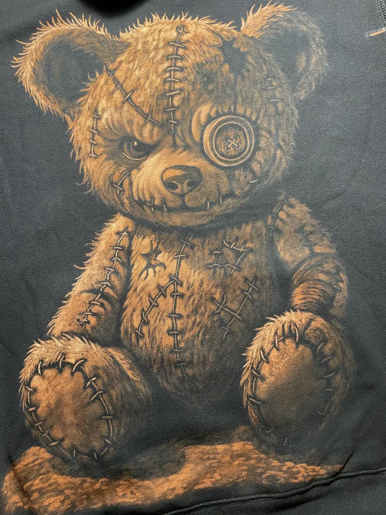 Close-up of a hand-bleached teddy bear illustration on a hoodie