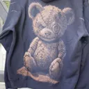 Daylight video showing a teddy bear bleach art illustration on the back of a fleece hoodie