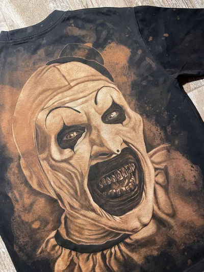 Angled view of the hand-painted Art the Clown portrait on the back of the black T-shirt
