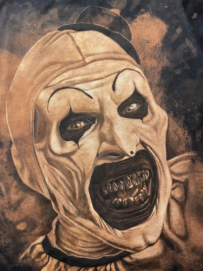 Close-up of Art the Clown’s face, dark eye makeup and detailed teeth in the back design