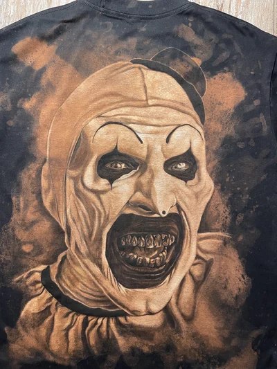 Closer view of the Art the Clown portrait painted with bleach and textile paint on the back of the T-shirt