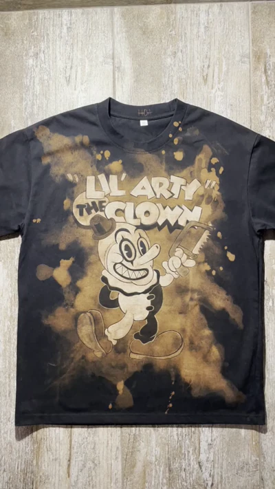 Video showing the full front of a Terrifier T-shirt with a miniature cartoon Art the Clown design