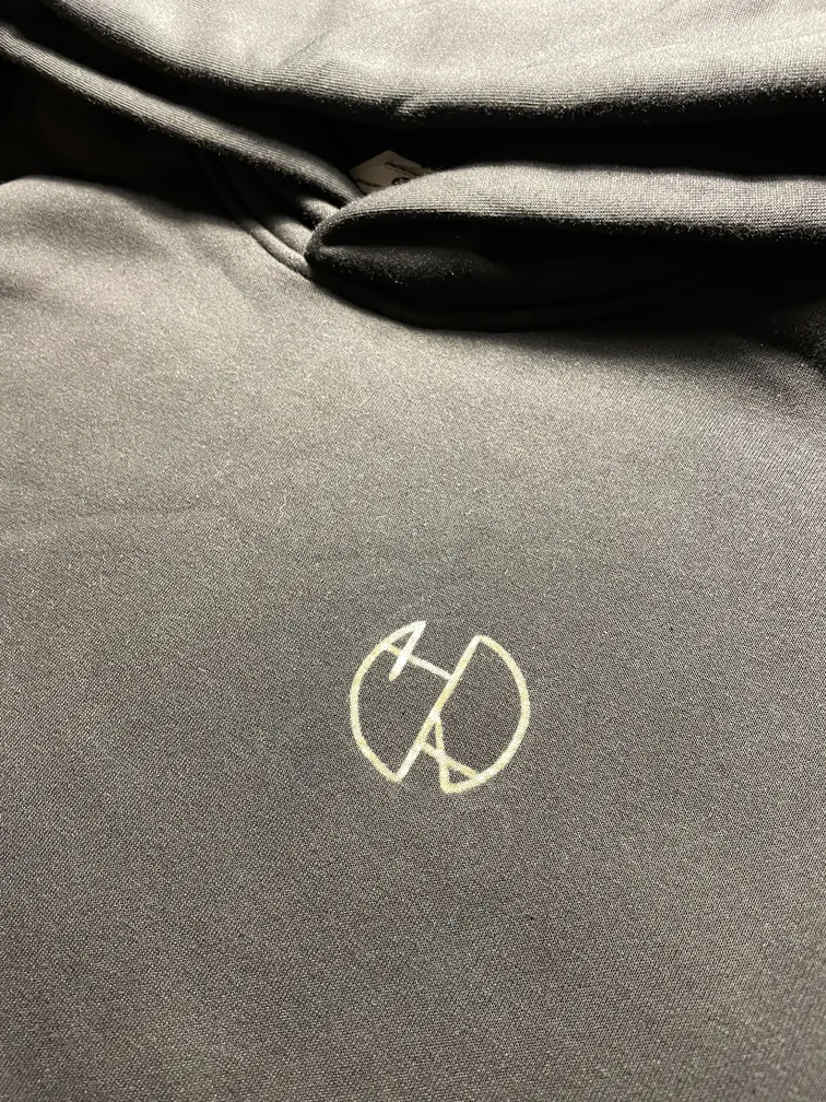 Close-up of the Helen Oben Art logo on the front of the hoodie