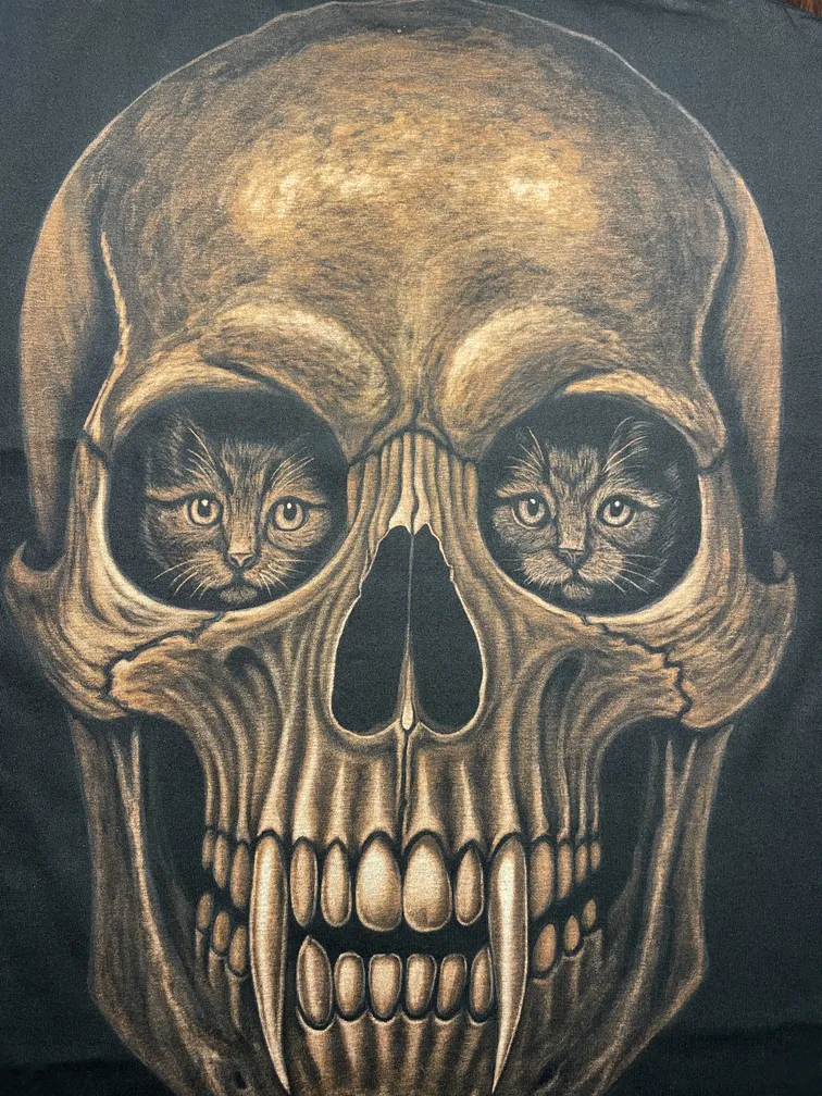 Close-up of a vampire skull illustration with kittens inside the eye sockets