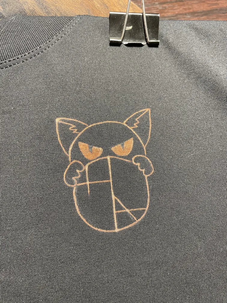 Close-up of the Helen Oben Art logo on the front of the t-shirt